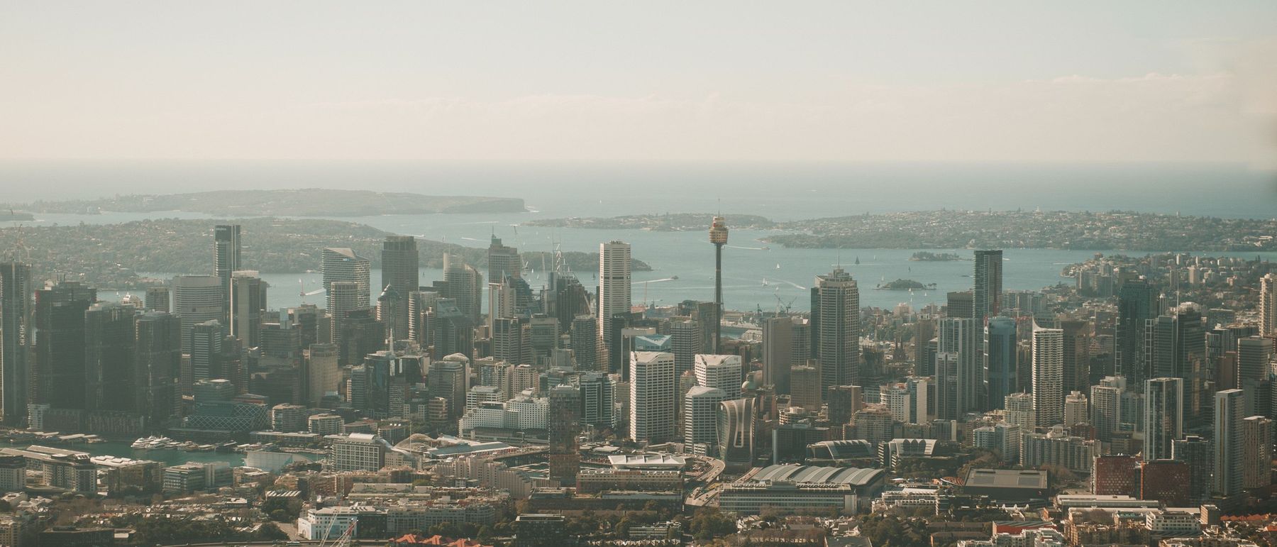 Aerial view across the Sydney central business district to the harbour, Sydney Tower and the heads beyond